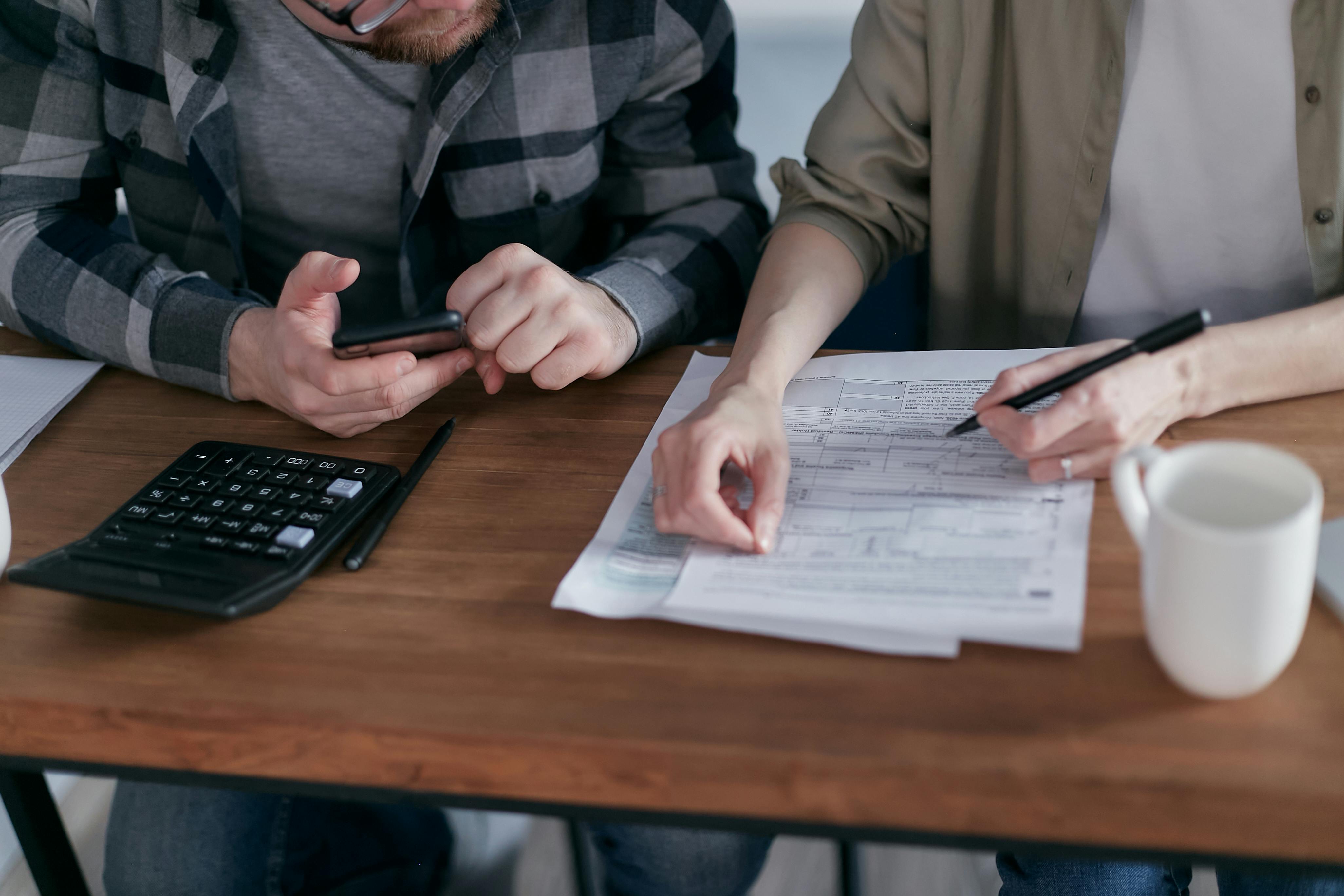 Two people making calculations and filing taxes together